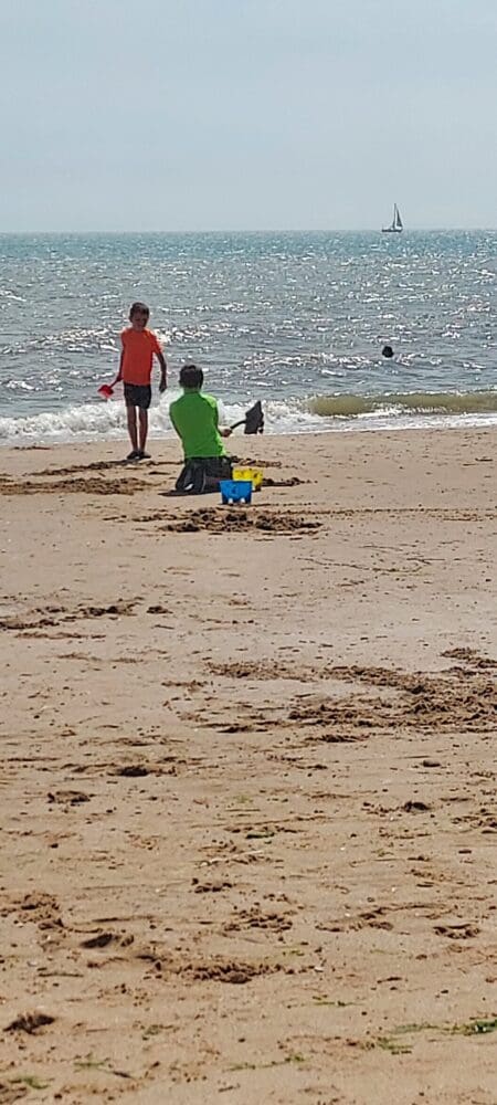 Two boys playing with buckets and spades on the beach
