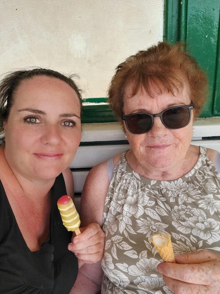 Two women enjoying ice creams together on a sunny day