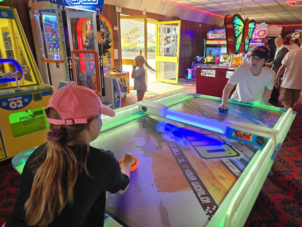 Children playing air hockey at a seaside arcade