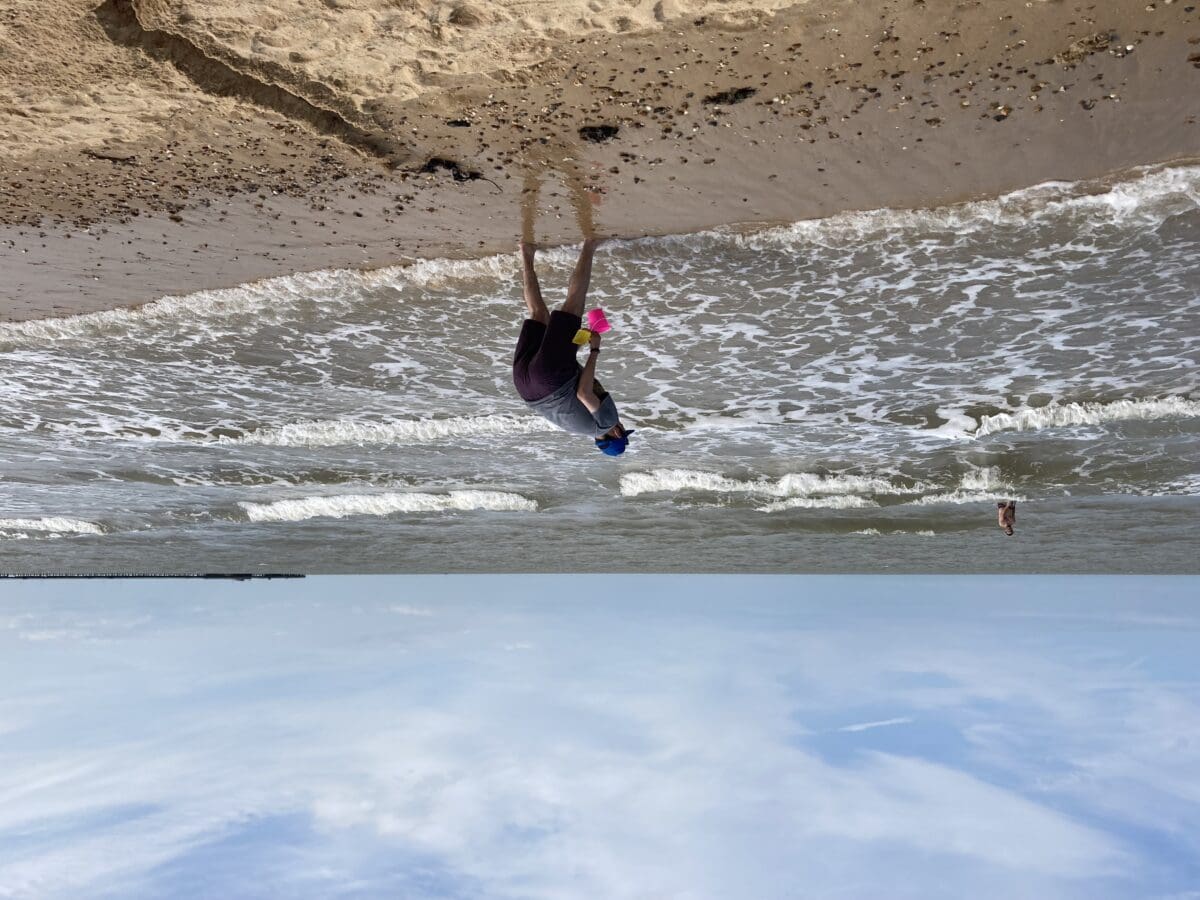 Cartwheeling on the beach with colourful buckets during a seaside trip
