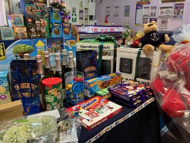 Christmas raffle table with Terry's Chocolate Orange, Baileys and Lego prizes