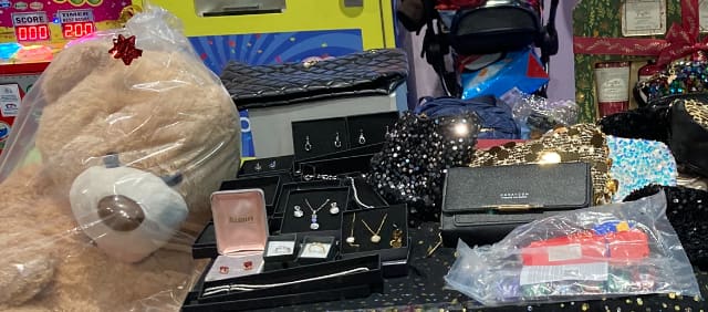 Teddy bear alongside jewellery and handbag raffle prizes at a RAGS event