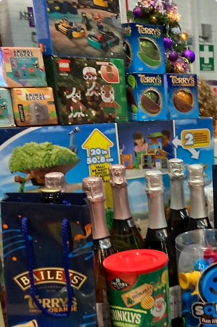 Close-up of Christmas raffle prizes including chocolate oranges and Lego sets