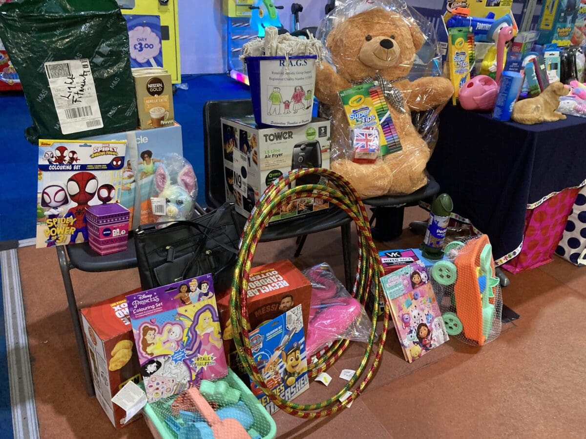 Raffle prizes including a teddy bear and RAGS collection bucket at a fundraiser