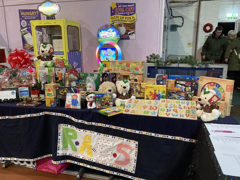 Christmas raffle prize table with teddy bears and gifts at a RAGS event