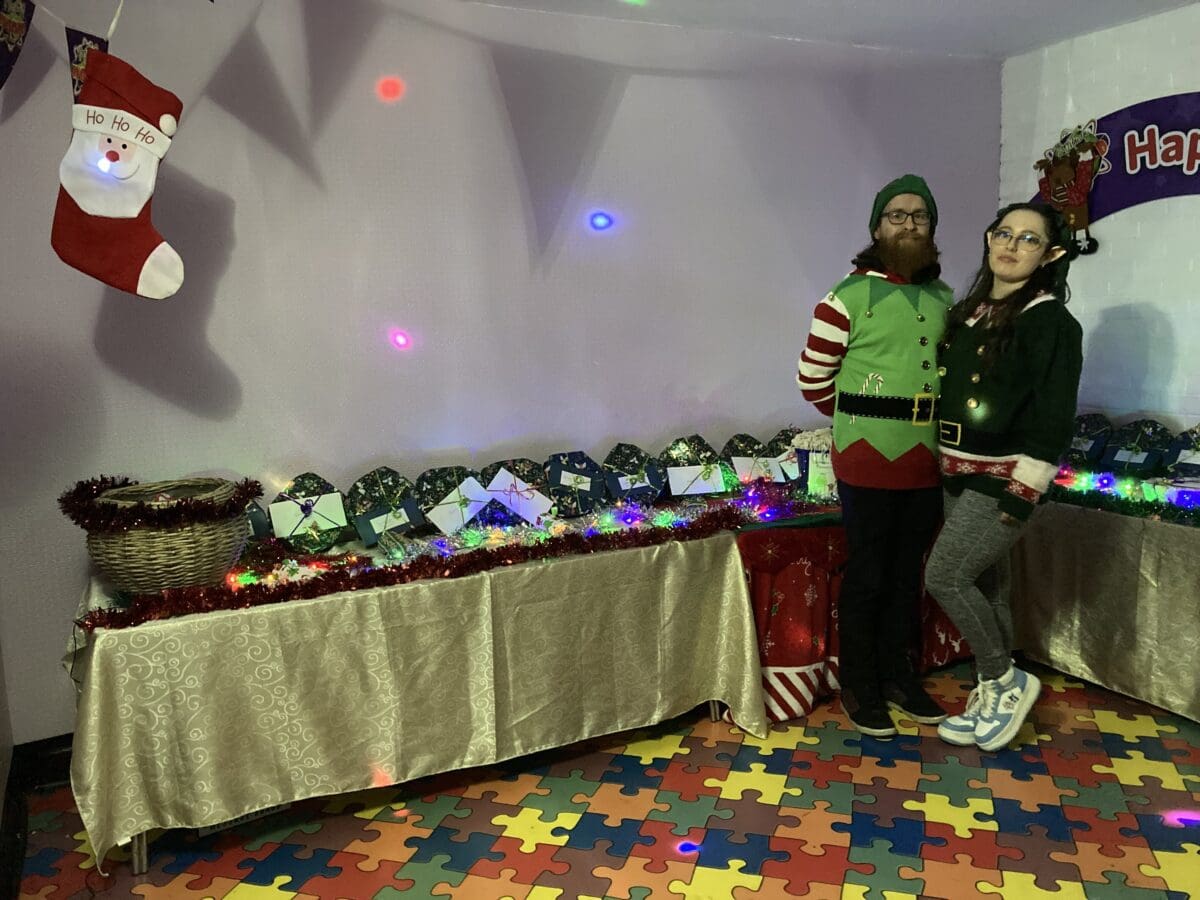 Two volunteers dressed as elves at a RAGS Christmas event