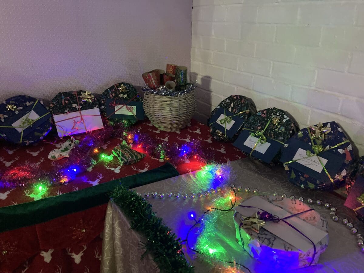 Wrapped Christmas raffle gifts on tables decorated with tinsel and fairy lights