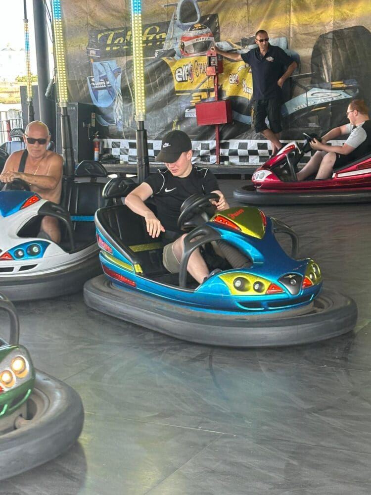 People riding dodgems at a fairground, 2024