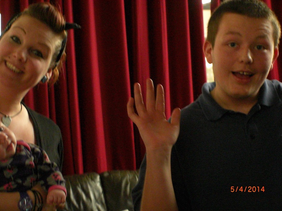 Family members at a RAGS event, young man waving at the camera, 2014