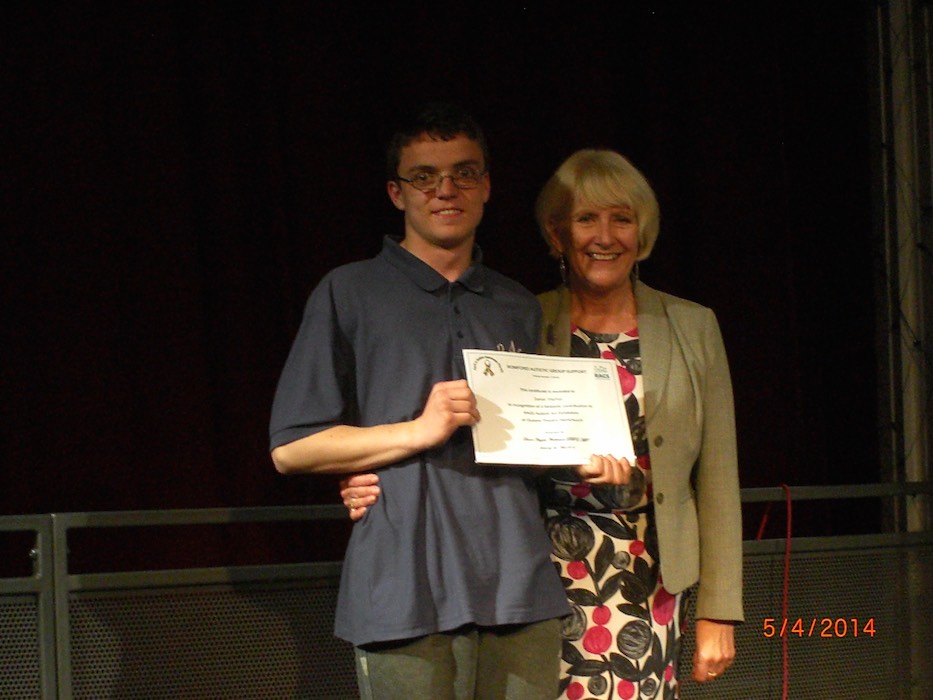 Young man receiving a certificate from a RAGS presenter on stage, 2014