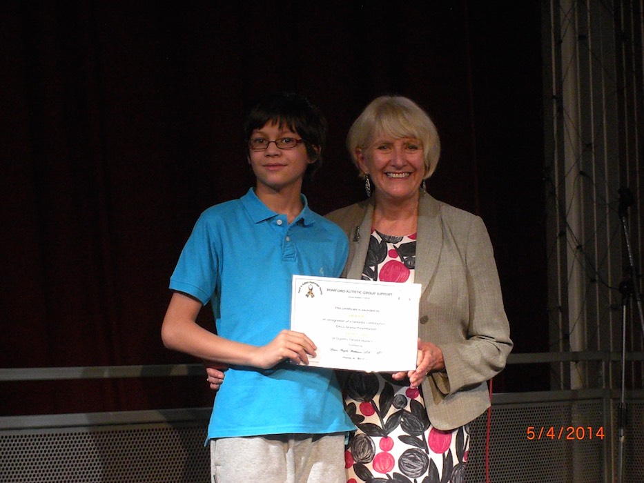 Teenage boy proudly holding his RAGS award certificate, 2014