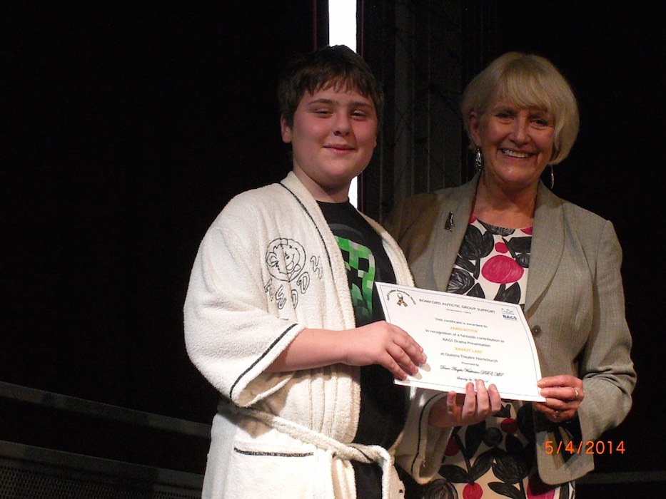 Boy in costume receiving a RAGS Drama Presentation certificate, 2014