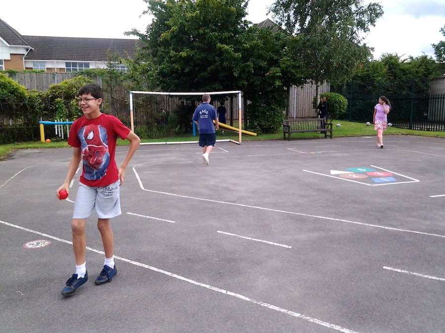Boy playing ball games in the school playground, RAGS summer club 2014