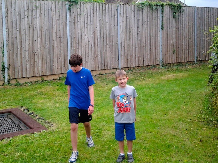 Two boys walking across the lawn at a RAGS summer activity, 2014