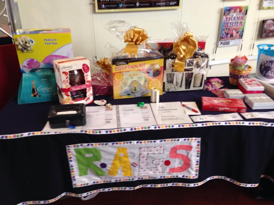 Raffle prizes and gift hampers on a RAGS table at a fundraising event