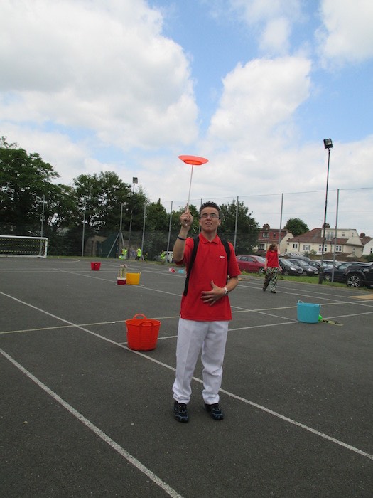 Young man spinning a plate on a stick at a circus skills event, 2014