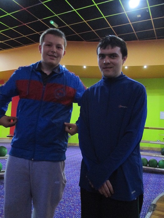 Two young men posing together at a ten-pin bowling alley, 2014
