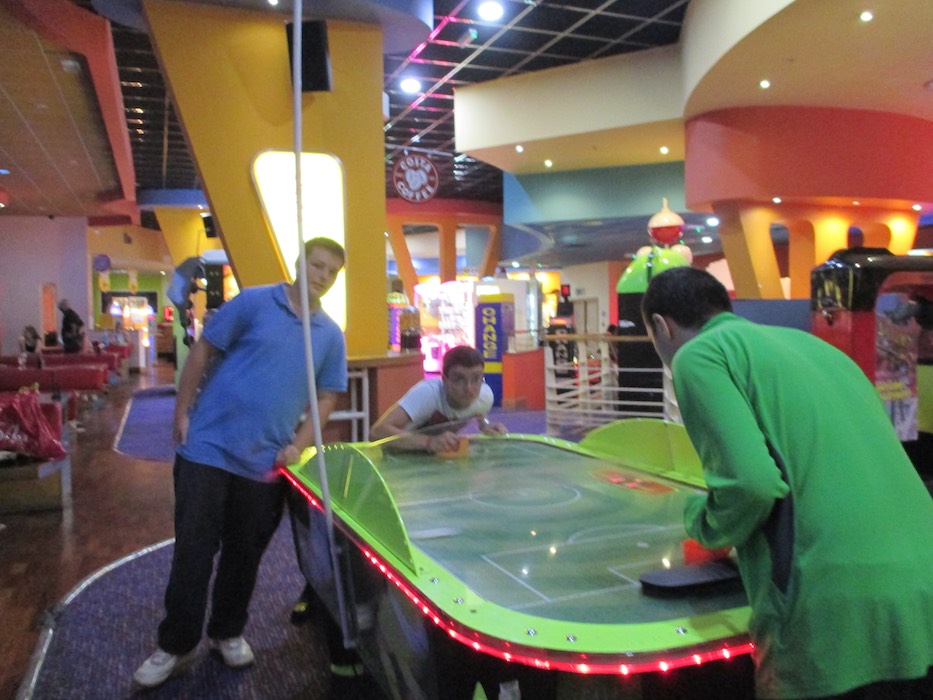 Members playing air hockey together at an entertainment centre, 2014