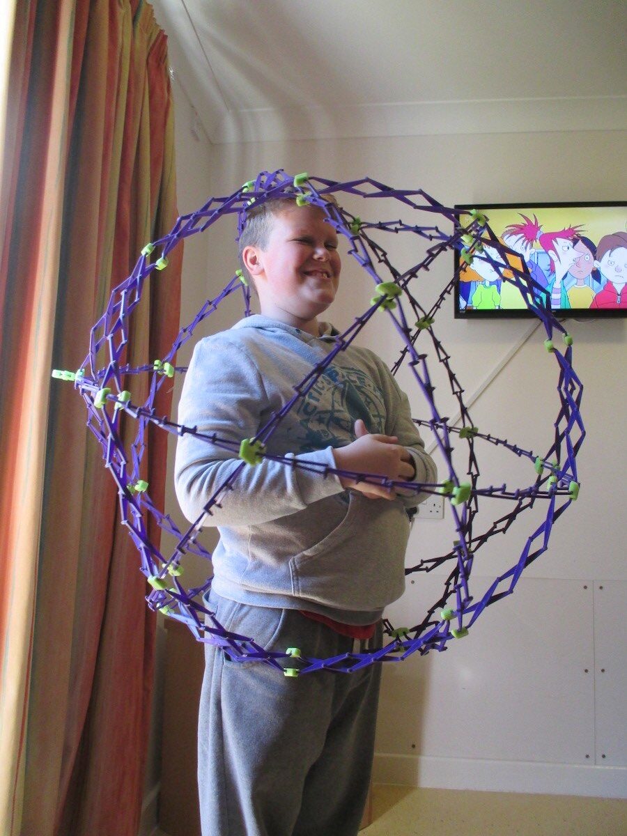 Boy playing with an expandable sphere toy at home, 2014