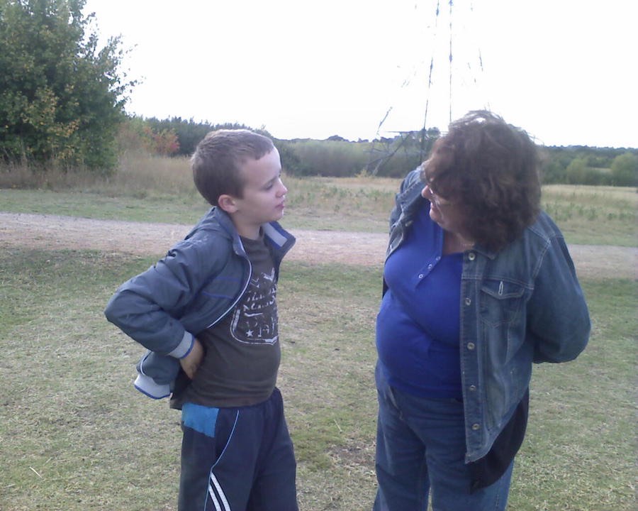 RAGS teenager chatting with a volunteer outdoors in a field, 2014