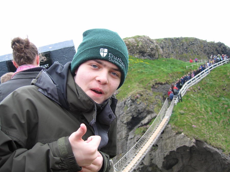 Young man giving a thumbs up on a rope bridge day trip, 2014