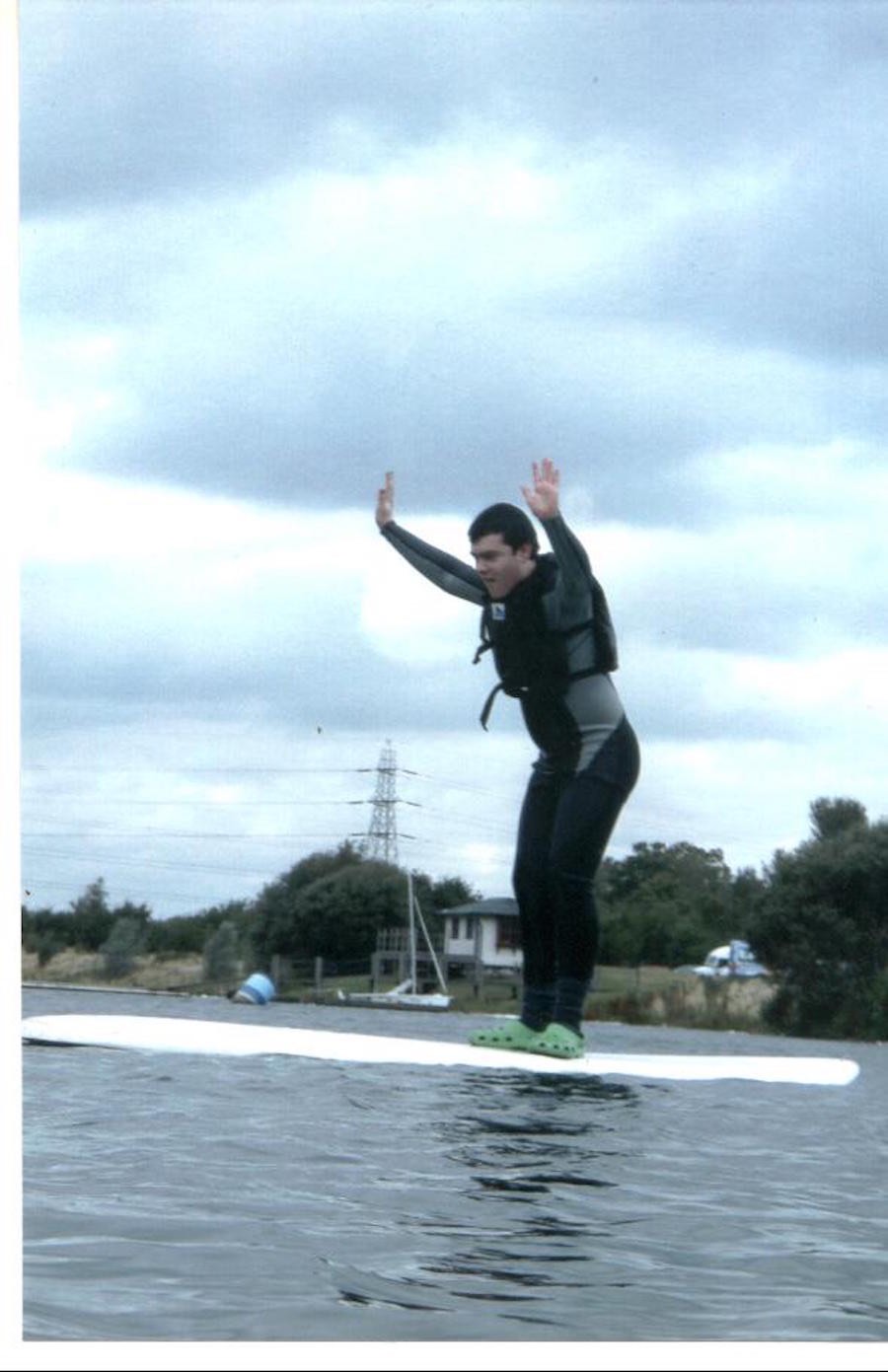 Teenager balancing on a paddleboard wearing a life jacket, 2014