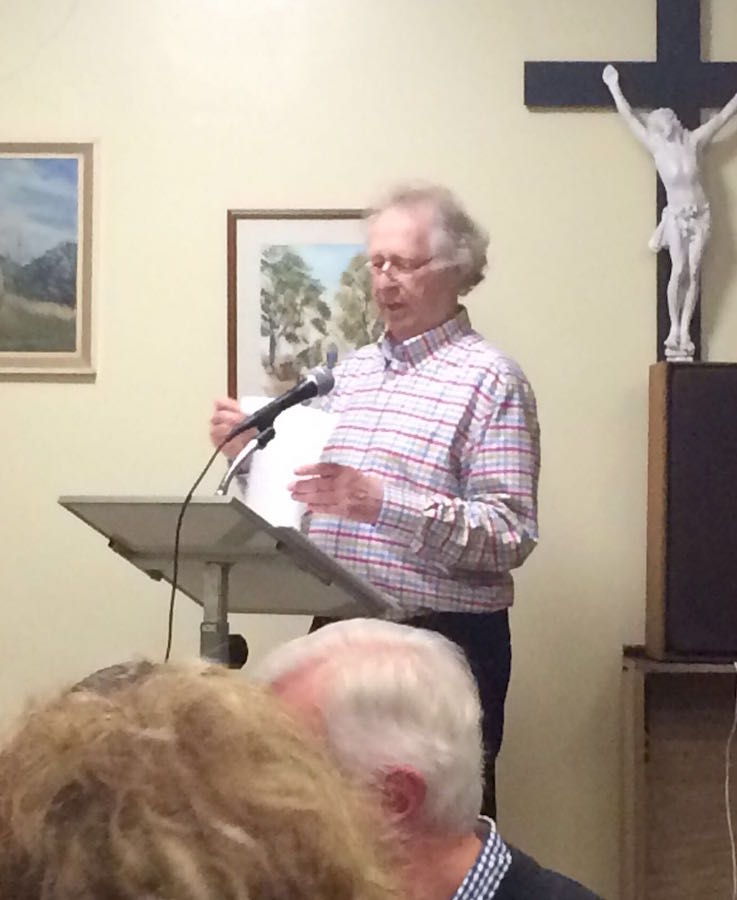 Man speaking at a podium during a RAGS quiz night, 2016