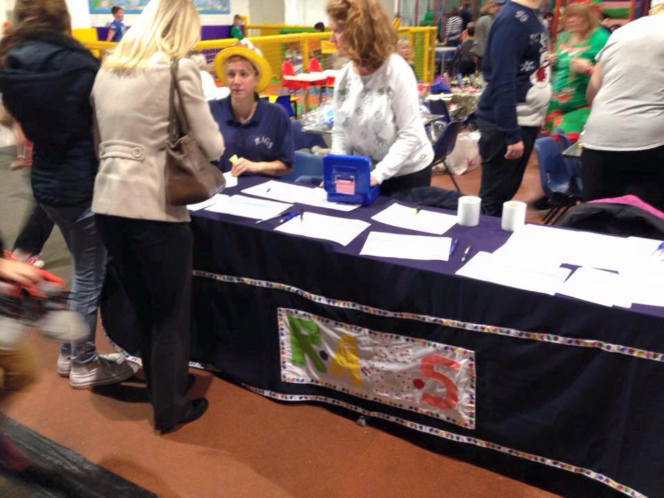 RAGS volunteers at a registration table during a Christmas event at a soft play centre
