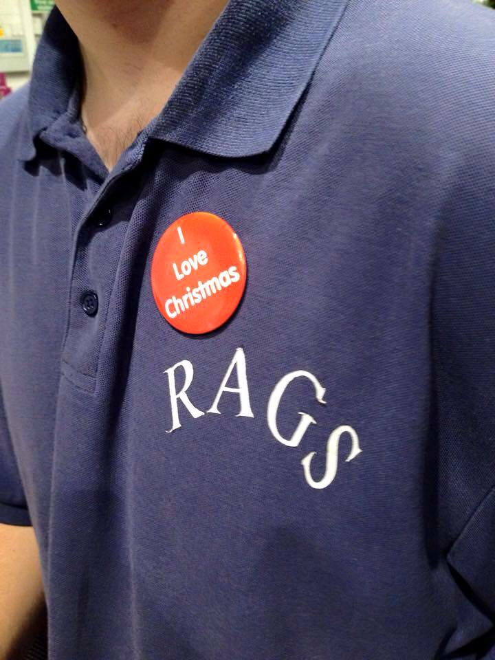 Close-up of a RAGS volunteer's polo shirt with an I Love Christmas badge